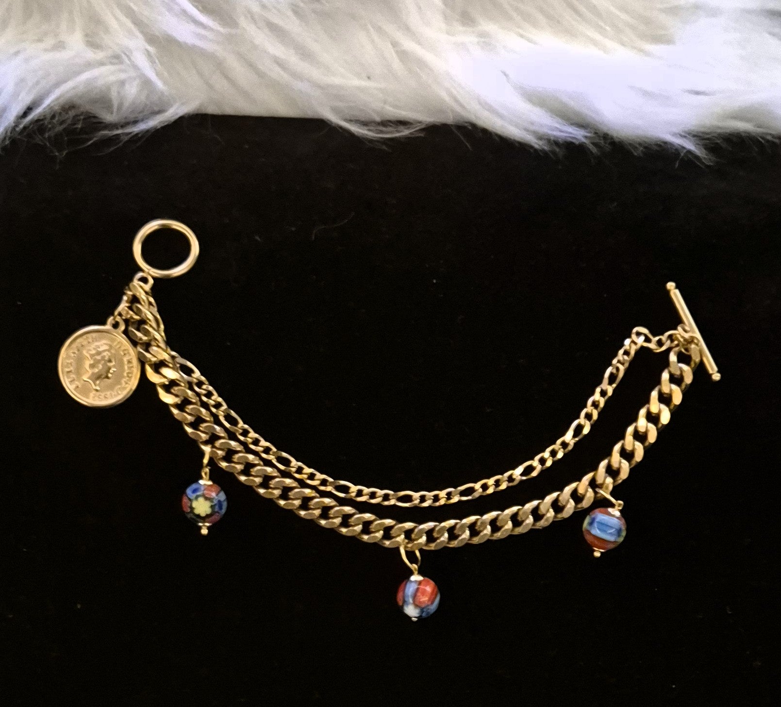 SuRosha Royal Essence – Goudkleurige schakelarmband met A la Kondre kralen & muntbedel