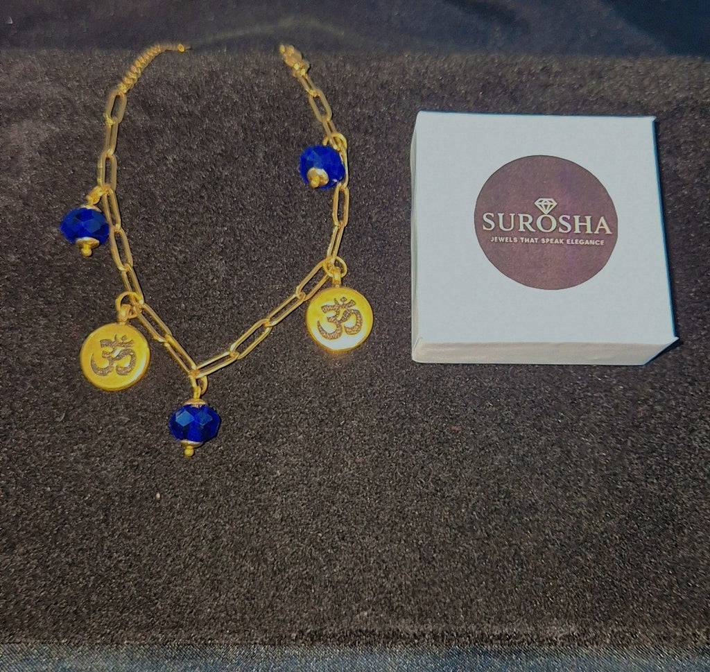 SuRosha OHM Armband Blauw – goudkleurige schakelarmband met blauwe ogri ai kralen & Ohm-bedels
