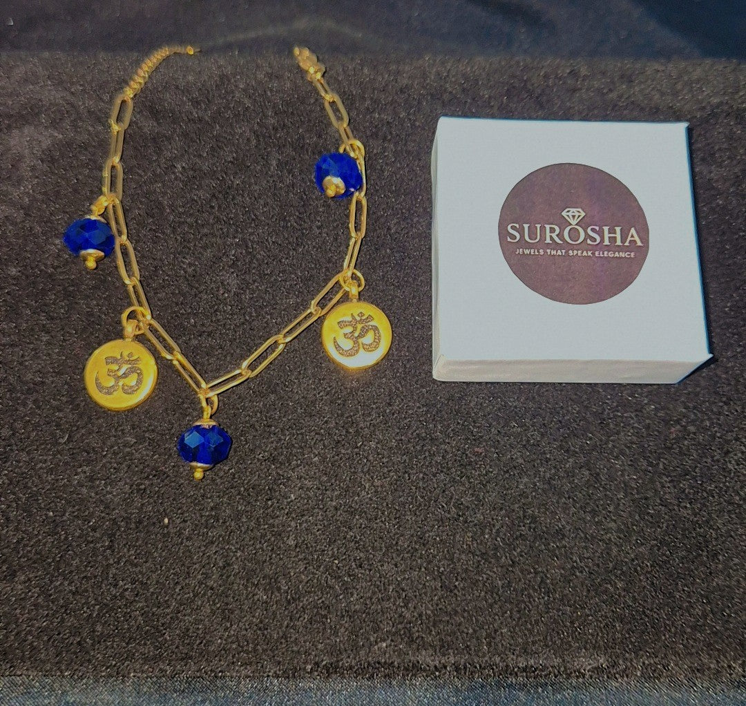 SuRosha OHM Armband Blauw – goudkleurige schakelarmband met blauwe ogri ai kralen & Ohm-bedels