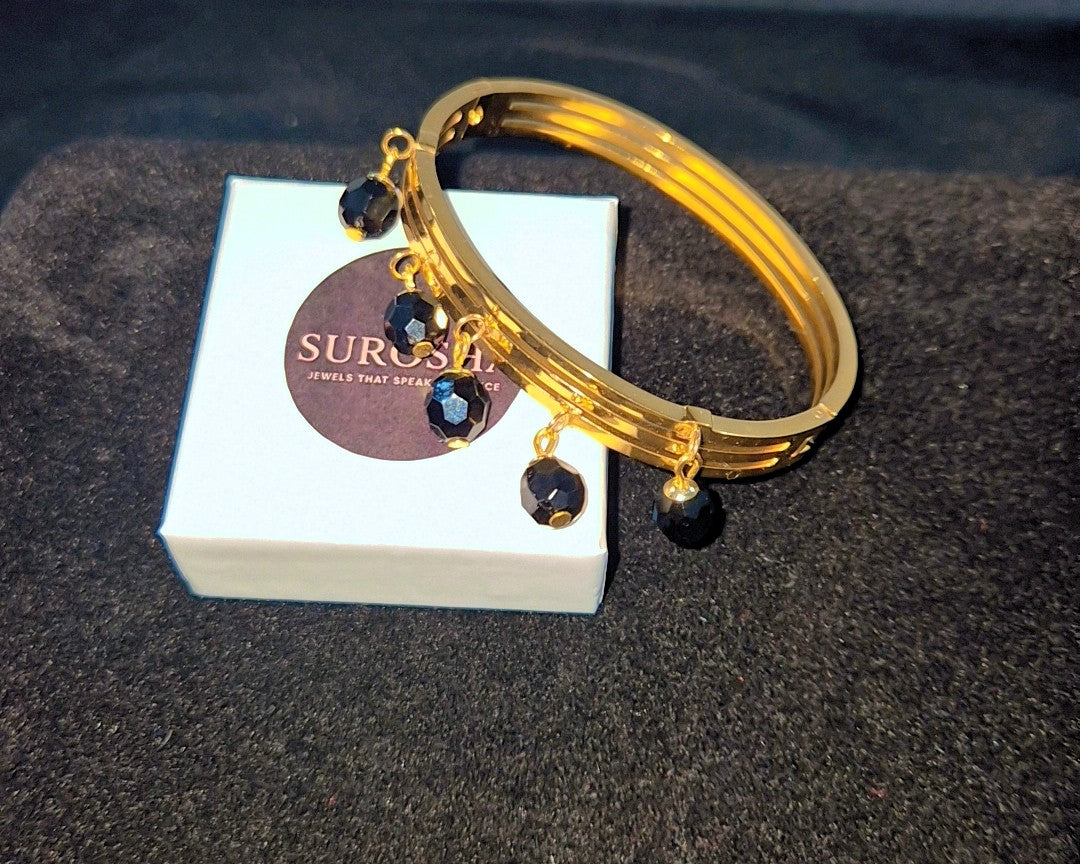 SuRosha goudkleurige bangle armband met zwarte Ogri Ai kralen