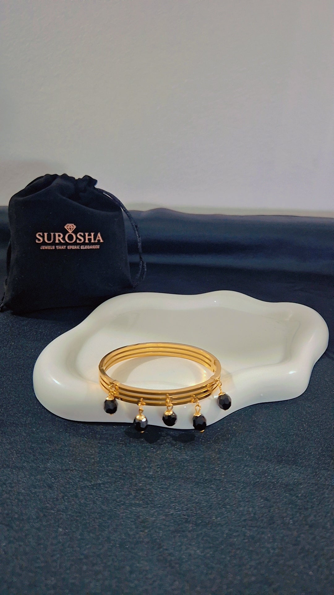 SuRosha goudkleurige bangle armband met zwarte Ogri Ai kralen