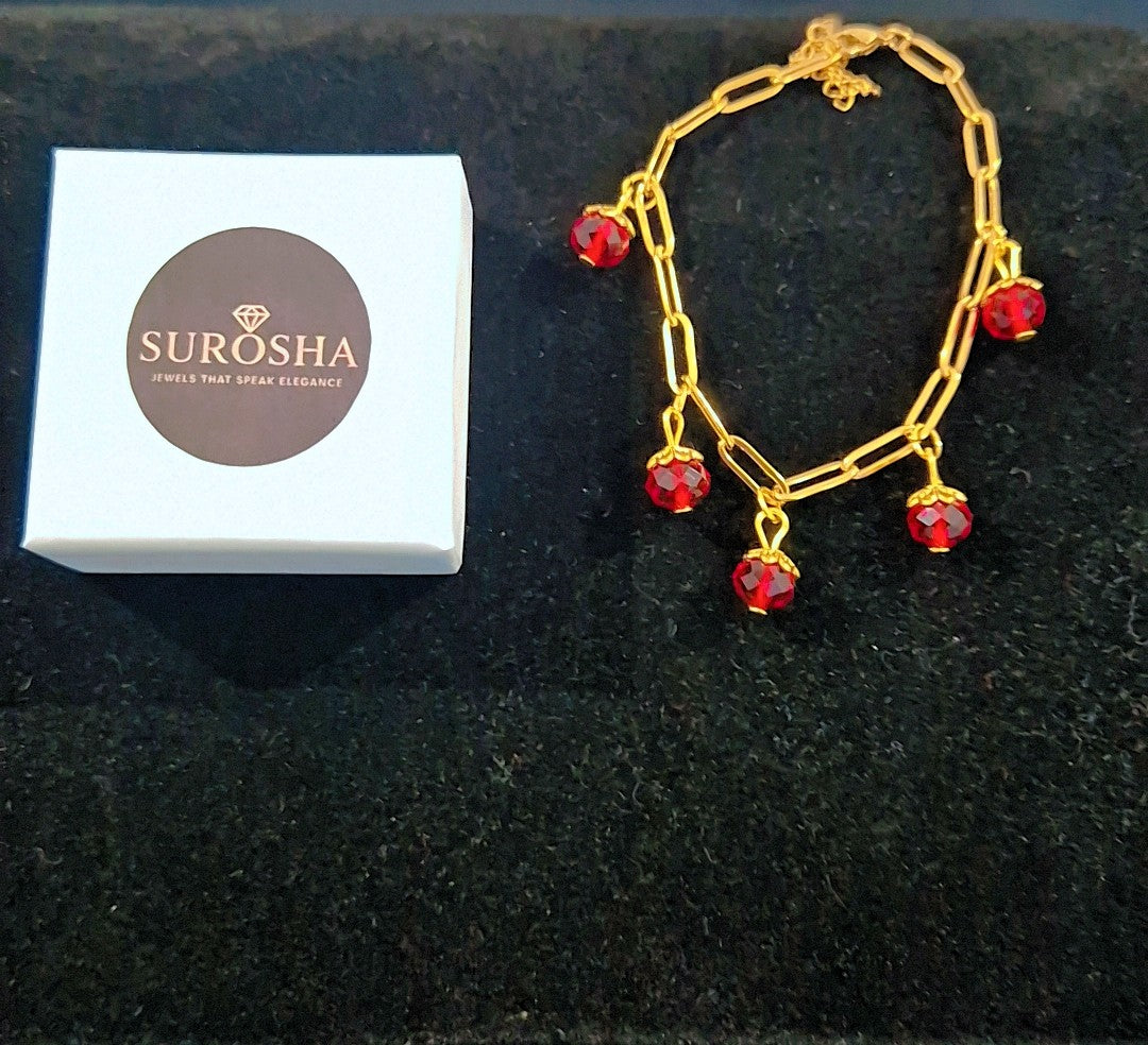 SuRosha goudkleurige schakelarmband met rode Ogri Ai kralen