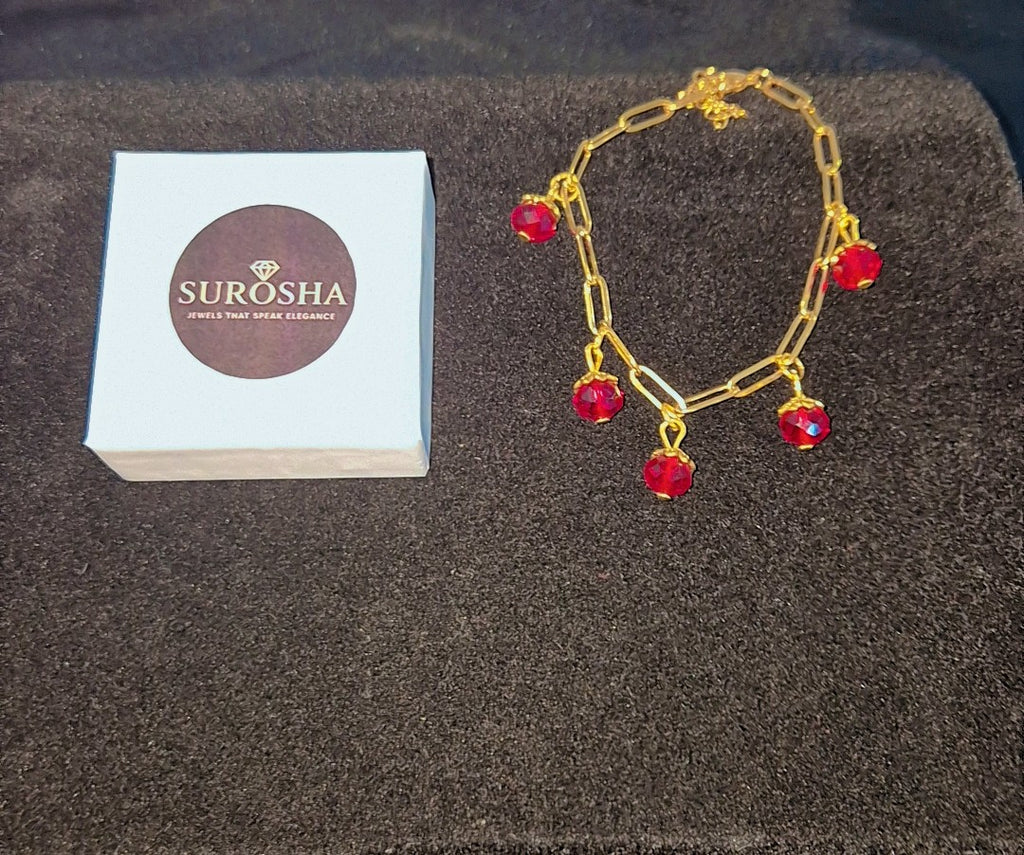 SuRosha goudkleurige schakelarmband met rode Ogri Ai kralen
